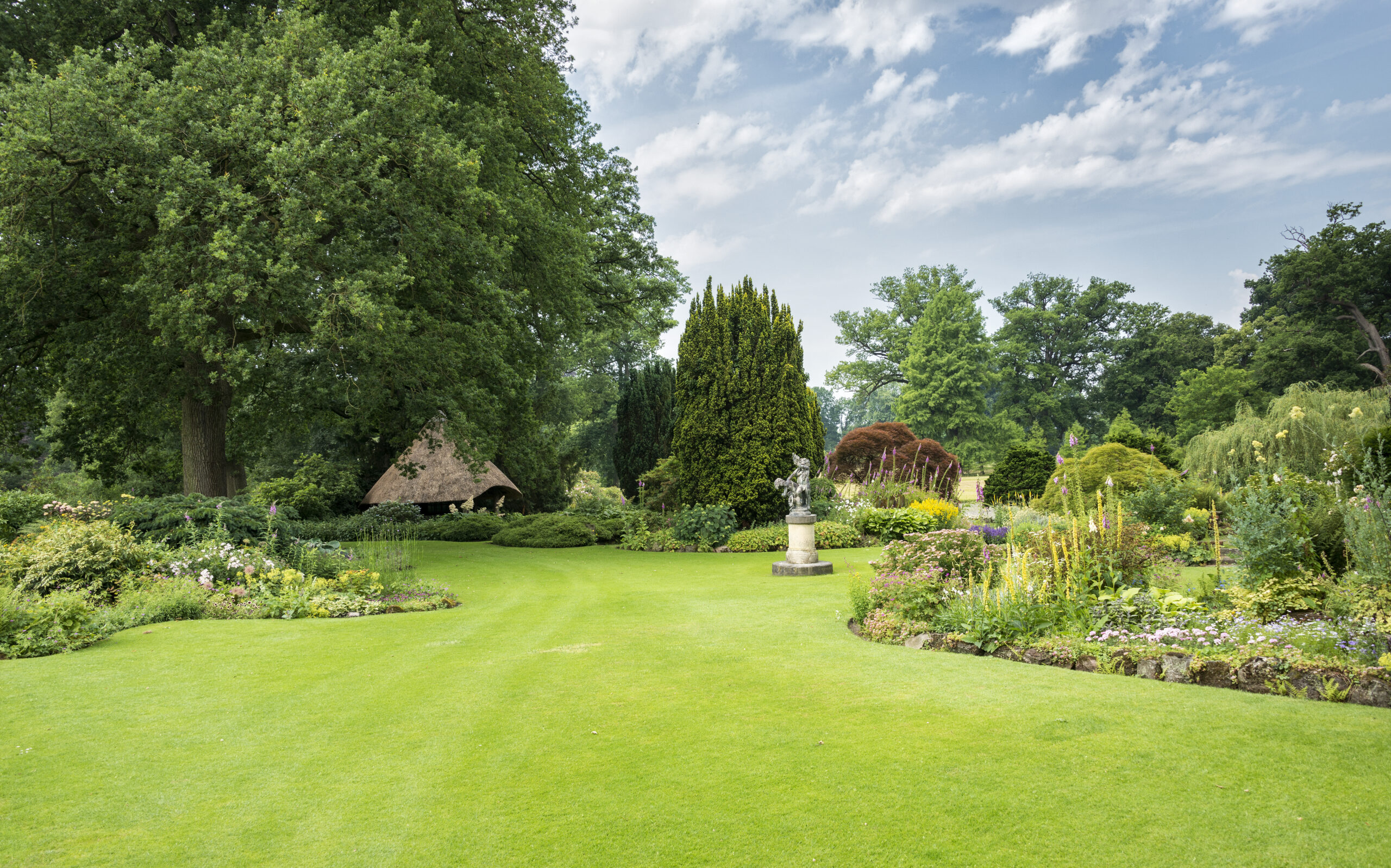 big green gardenwith ngreen grass flowers and gardenhouse